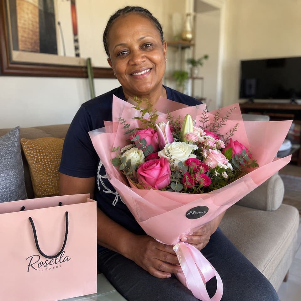 A customer enjoying a pink and white Rosella bouquet at home