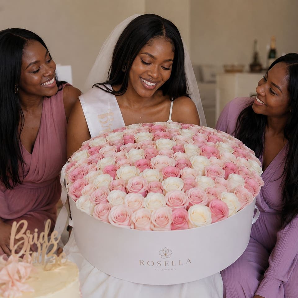 A bride-to-be with friends and an oversized pale pink rose arrangement